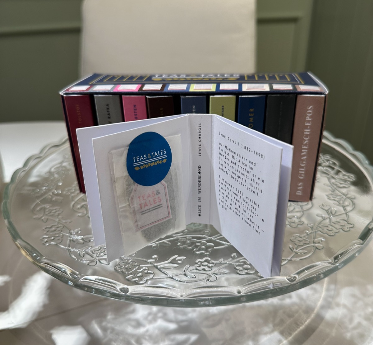Aufgeschlagenes Mini-Buch mit Teebeutel und Einführung ins Werk