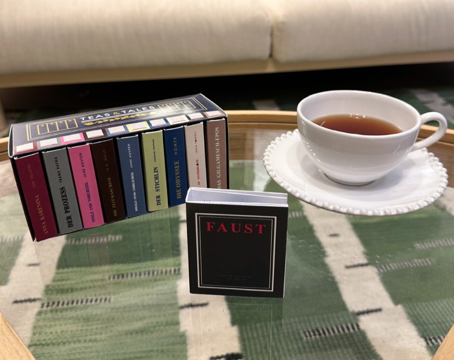 Faust Mini-Buch aufgestellt vor der Box, daneben eine Tasse Tee